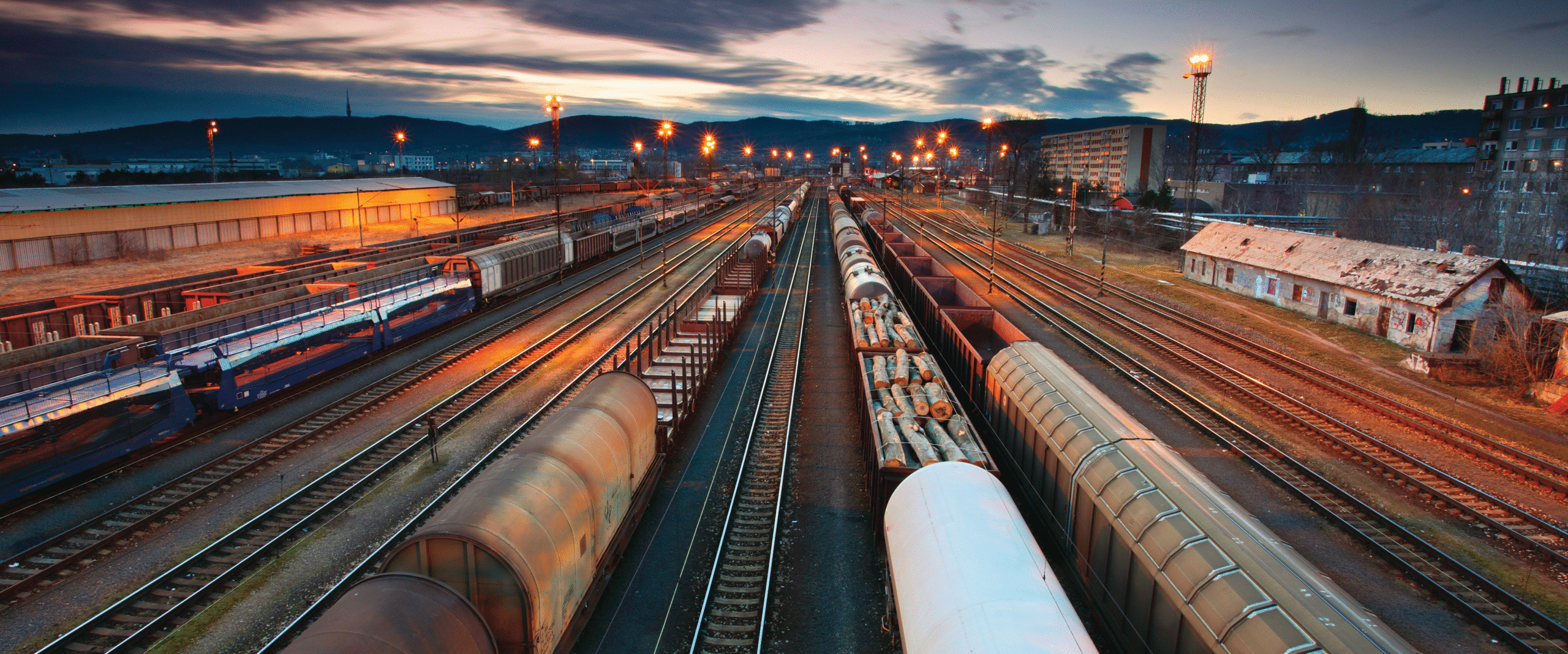 Freight train station at sunset with cargo trains.