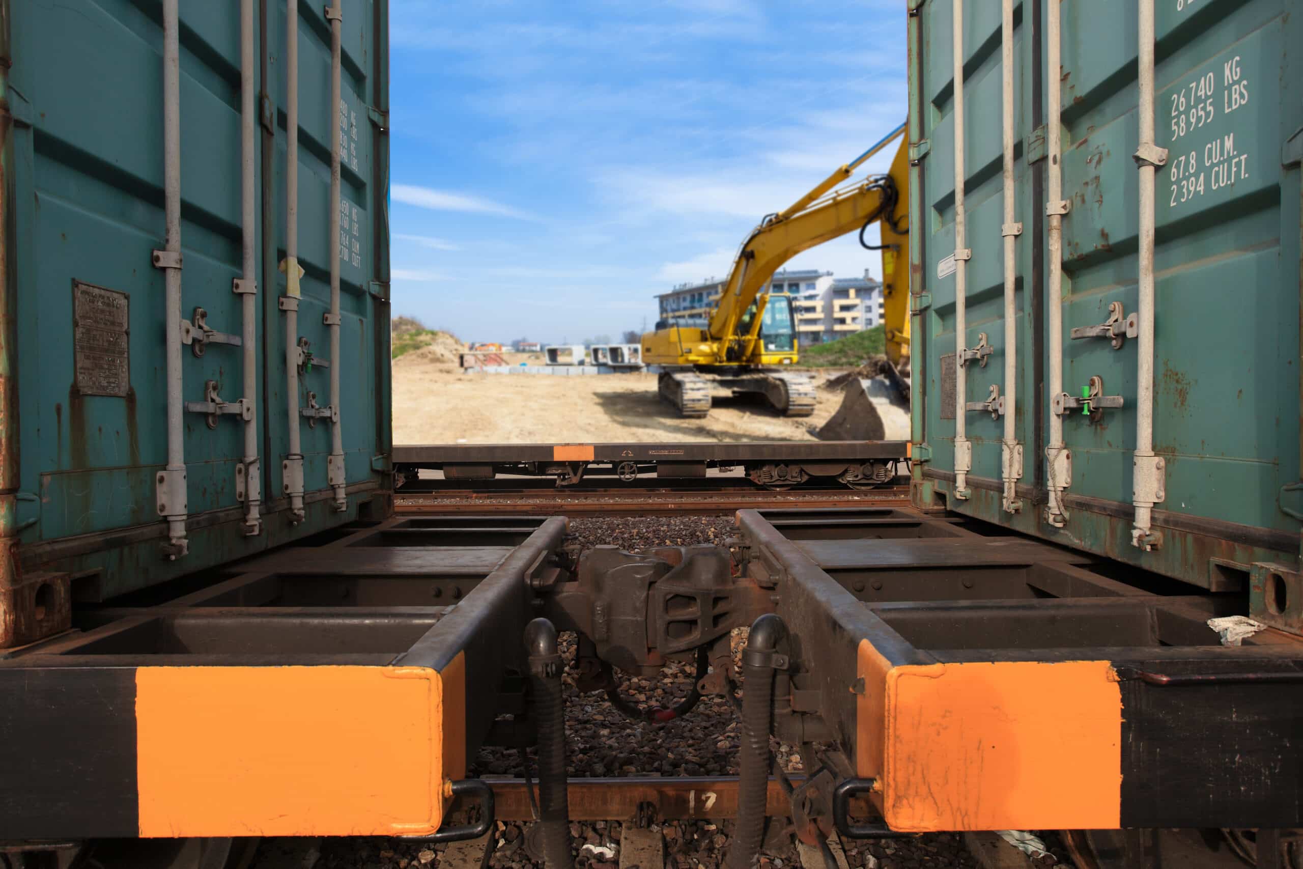 View between train cars with construction site