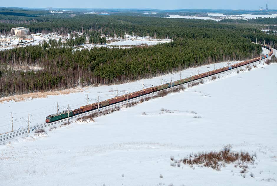 Train passing through snowy forest landscape.