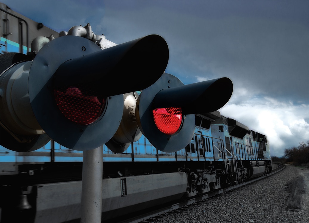 Train passing behind railway crossing signals